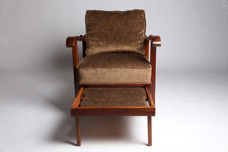 This reclining chair comes with a foot rest and is made from solid Walnut.