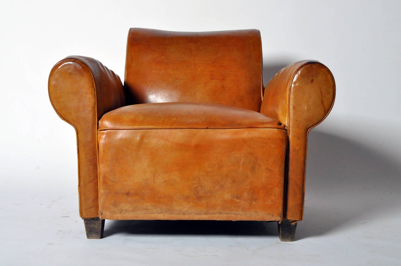 Made from beautifully aged light tan leather, the chairs slightly reclined back lends additional comfort to the soft cushioned seat and wide rounded arms.