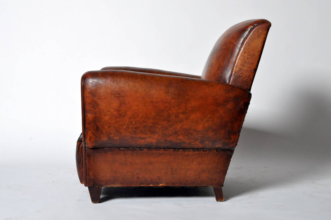 Handsome brown sheepskin covers the rectangular back and rounded arms. It is raised on short, tapering wood feet.