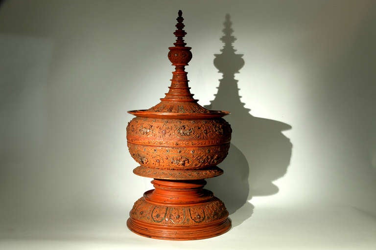 This exceptionally large Burmese offering urn is made from teak and bamboo covered by many layers of natural red lacquer.   It is further adorned with glass mirror fragments that create a bejeweled appearance. 