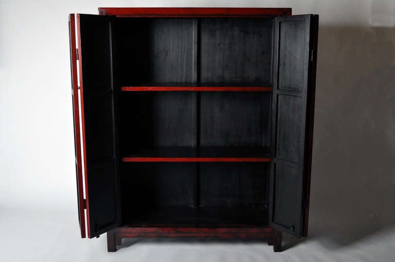 This amazing 19th Century Chinese clothing cabinet is made from Elm Wood and has an oxblood lacquer finish. Made in Shanxi, China c. 1870 this piece had restoration work done.