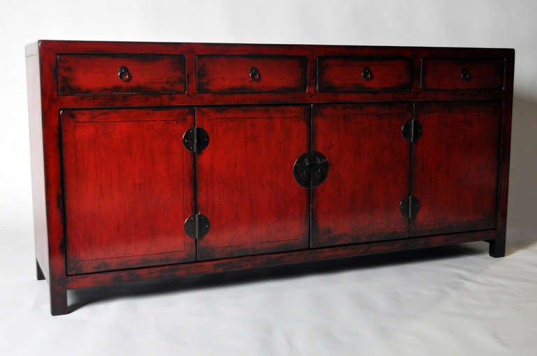 This 19th century, red lacquered side chest is made from Elm Wood and has four drawers. This piece is from the Henan Providence in China and dates to the mid-19th century. It features traditional mortise-and-tenon joinery. No nails were used and