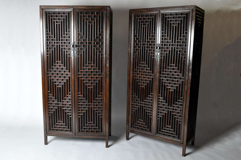 This elegant pair of 19th century Chinese cabinets are made from Elm wood and have beautiful lattice doors. This pair is from the Jiangsu Providence in China and dates to the early-19th century. It features traditional mortise-and-tenon joinery. No
