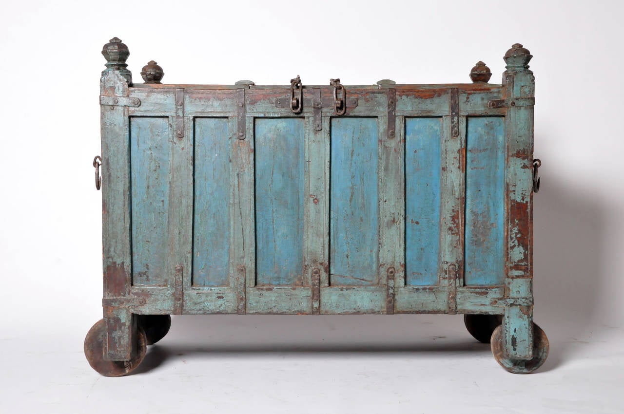 Storage never looked more beautiful; this richly patinated cache has a hinged lid that can be secured by Dual chains. This rectangular Indian wedding chest has decorative finials at each corner and the whole is raised on wheels. It can also serve