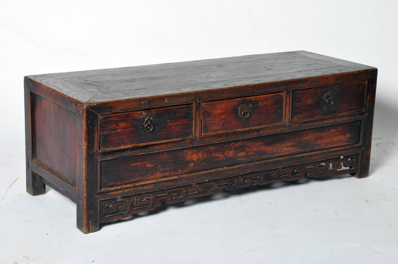 Chinese elmwood chest with an aged reddish-brown patina, this Kwang style low chest has three pullout drawers.