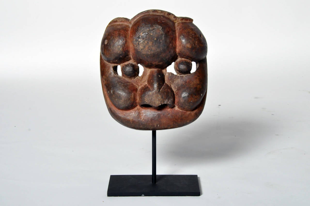 Functionally hand carved to include open silts around the eyes for the wearer to view their surroundings, this mask has a well aged patina covering the red lacquer paint and is raised on a contemporary metal stand.
Late Qing Dynasty