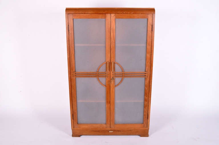 This beautiful Art Deco cabinet is from Burma and is made from Teak Wood. This piece has frosted glass doors and 3 shelves inside for storage. The cabinet also comes with a key for the lock.