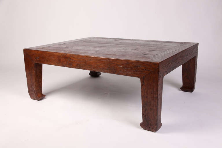 A Kang table is a type of Chinese furniture that serves a dual purpose as both a low table, and a chair-level bed that was sat on during the day. This specific piece features solid top raised on square-corner legs that terminate in horse-hoof
