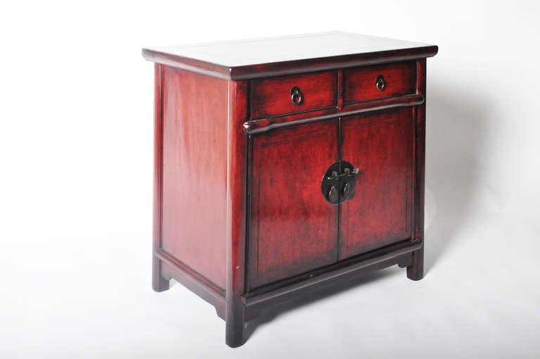 This gorgeous pair of 19th century tapered bed side chests are made from red lacquered Elm Wood. This piece is from the Zhejiang Providence in China and dates to the mid-19th century. It features traditional mortise-and-tenon joinery and floating