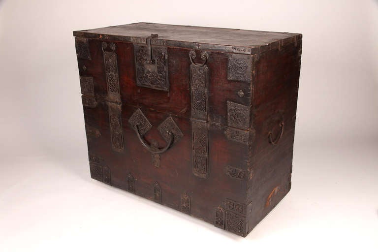 This Korean Chest is made from pine and its elaborate ironwork.  The symbols represent good fortune and well-being.  The hand-forged handle and clasp are massive in scale.  All patina is original.
