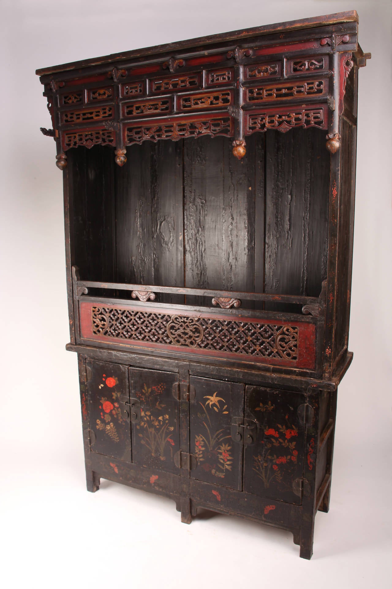 Made from black and red lacquered Elm Wood, this shrine is multifunctional as both a display and storage cabinet.

The top piece is decorated with segmented cloud-form openwork panels and hanging spandrel. The central latticework panel is carved