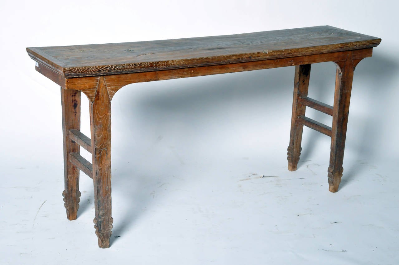 Inserted shoulder joints keep the table’s recessed legs flush with the plain apron. Just above the feet of each leg there are semicircle designs slightly protruding on both sides.
