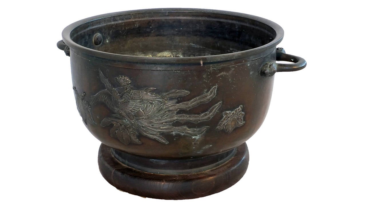 Raised from the dark patinated bowl, the relief decoration depicts a phoenix among leaves and foliage. Hibachi were traditionally used as heating devices and held burning charcoal to warm rooms.