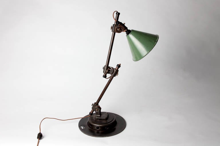 This versatile light likely sat on the desk of a watchmaker, or perhaps an architect’s drafting table. Sliding pivot joints connect the green shade and two cylindrical arms to the sturdy base, which allows for limitless adjust-ability.