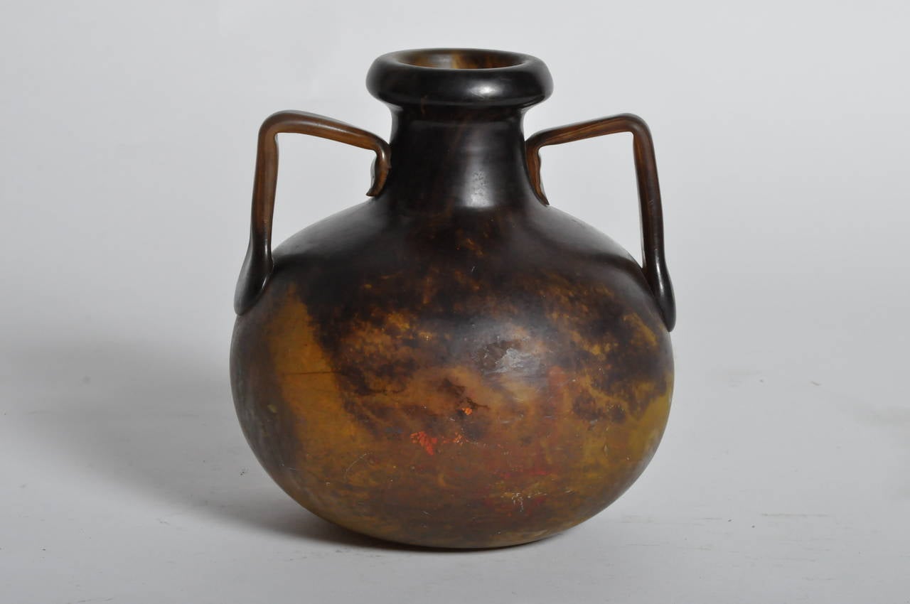 This black and brown colored jug has two applied handles attached to the neck and globular body.