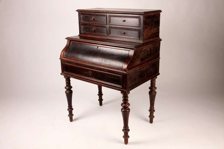 This late 19th century elegant roll top desk is made from walnut and oak veneer.  The desk has five drawers for storage space.