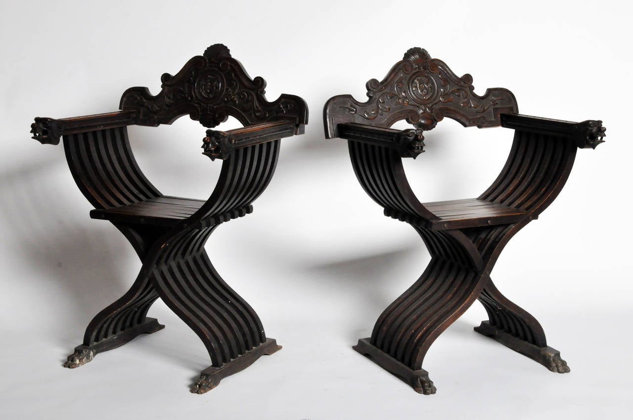 Also called Caquetoire or ‘gossip’ chairs, armchairs like these were arranged for conversational convenience. These X-frame armchairs have slatted frames, carved grotesque mask arms, and are raised on paw feet.