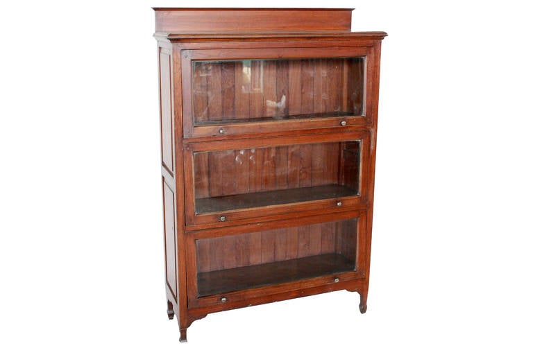 This Colonial bookcase was made in Burma from Teak Wood and dates to about 1910. Sturdy and compact, it offers a lot of book storage for its size. Door mechanism opens smoothly. Surface patina is original. Note the slats on the back - they are Teak.