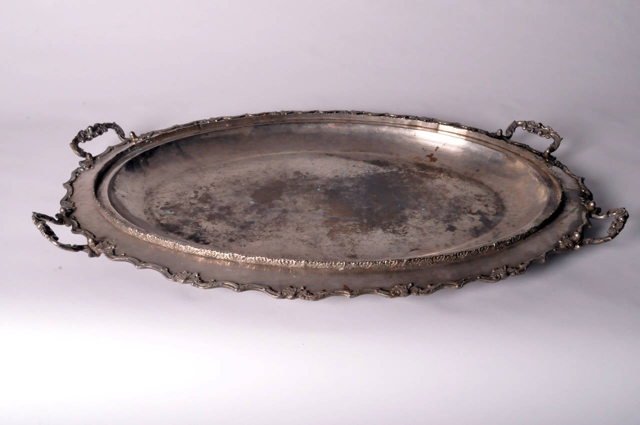 Of oval form, this impressively large tray has a deep well framed by a lip for a fitted lid that has since—and unfortunately—been separated from the base. The outer raised lip bears a repetitive geometric design while the rim is decorated with a
