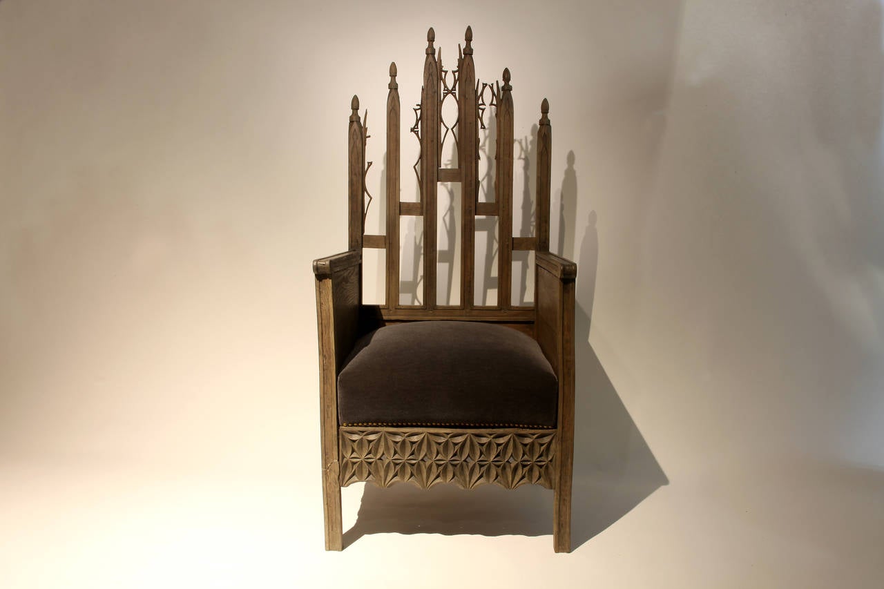 Exquisitely carved from Oak Wood, this imposing French chair was probably used in a church. Some of the filigree carving is missing but the effect is aesthetically pleasing - the chair has the appearance of a ruin. The cushion has been newly covered