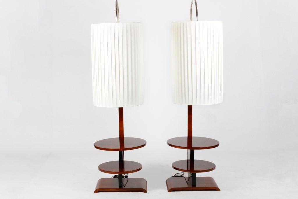 These unique Art Deco floor lamps have an arched chrome stems that each contain five sockets for a soft, all-over light behind the large fabric shade.  Walnut veneer covers the rectangular base and the round shelves.  The support wing is finished in