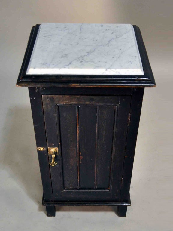 This British Colonial Tapered Side Chest has wood paneling with a dark finish on all four sides, a beautiful beveled white marble top and oil rubbed bronze drop hardware.  This side chest is as ideal for a bedroom as it is for a bathroom.