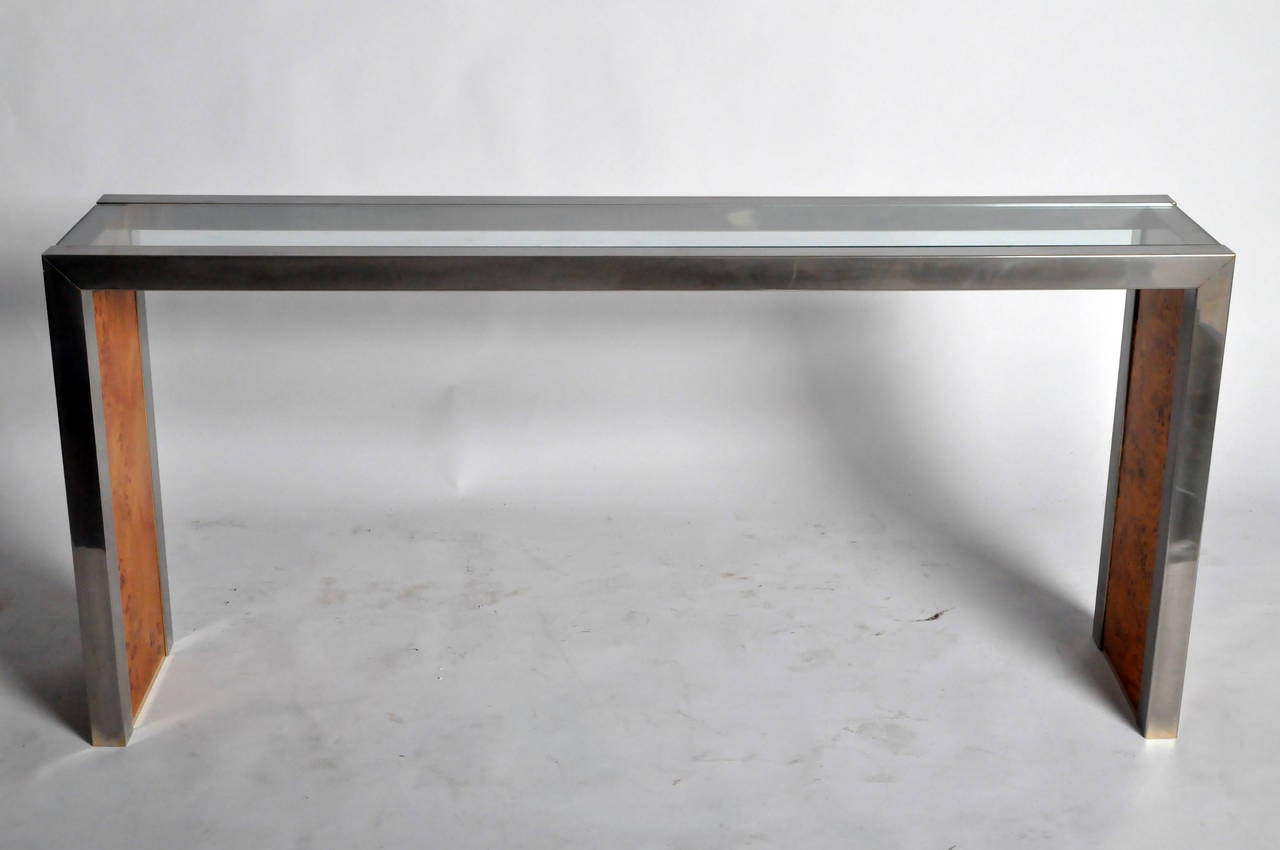 This unique console table features a chromed steel frame, an inset glass top and veneered walnut side panels.