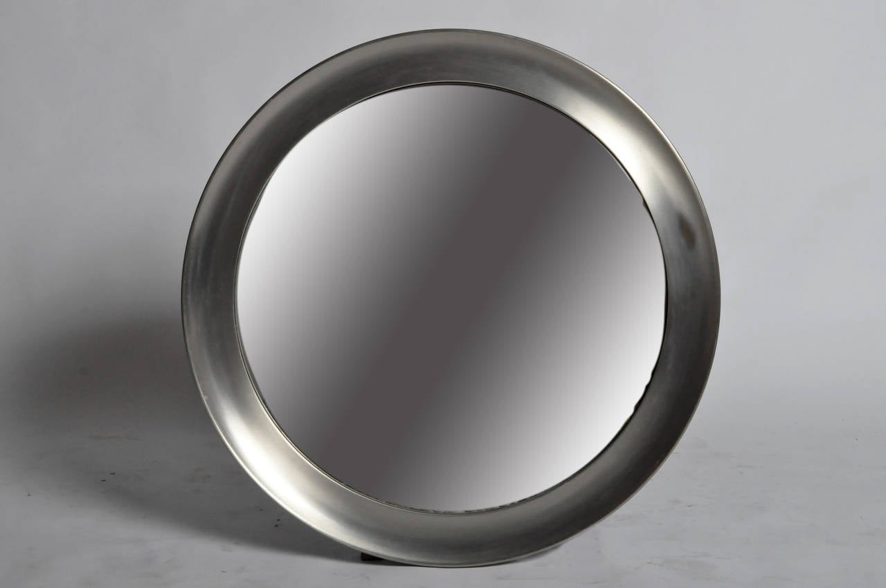 A prominent designer for Artemide, Sergio Mazza worked in furniture and Industrial Design. This circular mirror has a sleek and handsomely streamlined frame. Only one mirror is available. 