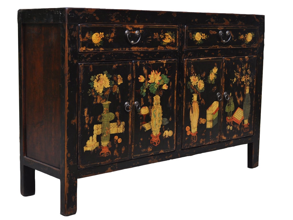 This playful 1850’s Chinese sideboard is covered in black-brown lacquer and decorated with colorful flowers, urns and fruit.  This type of painted is typical of Shanxi, China.