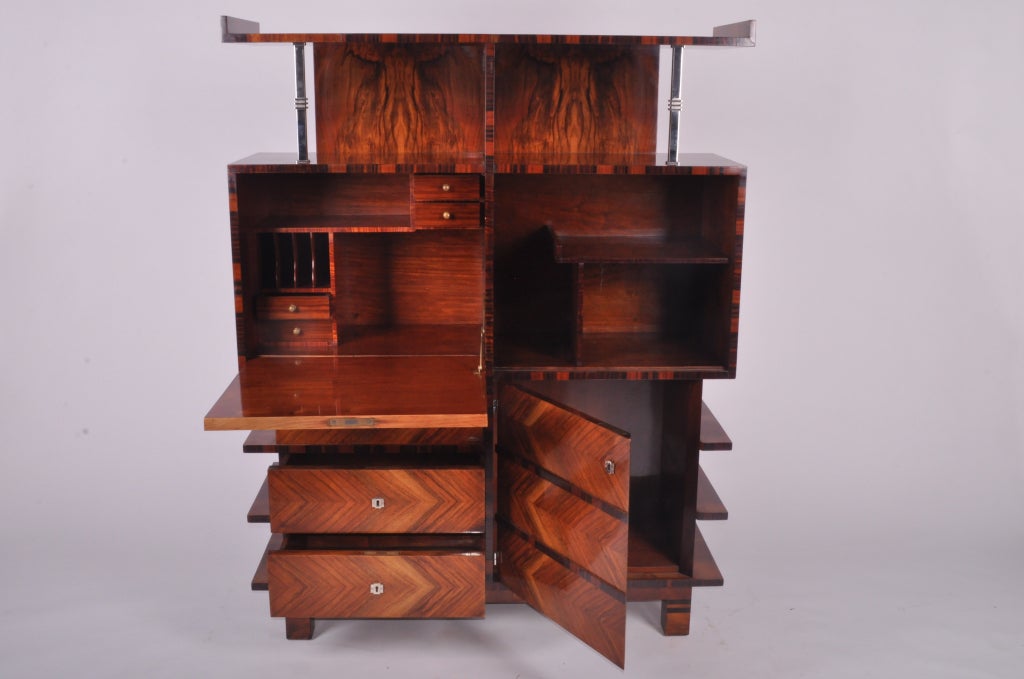 A superb example of Hungarian art deco furniture making. This piece features open and closed shelving, drawers, macassar and walnut veneers and chrome details.
