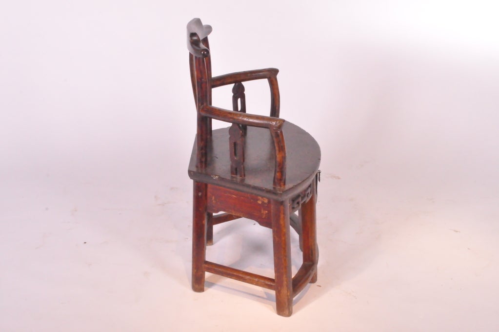 Beautiful fan-shaped arm chair with curved back panel and drawer with original patina.