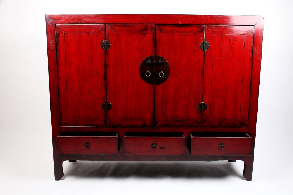 This red lacquered Chinese cabinet from Shanghai, China features a highly unusual intermediate height.  
It has clean lines and is suitable for many modern applications.  Hardware has been replaced and a number of wooden parts have been replaced to