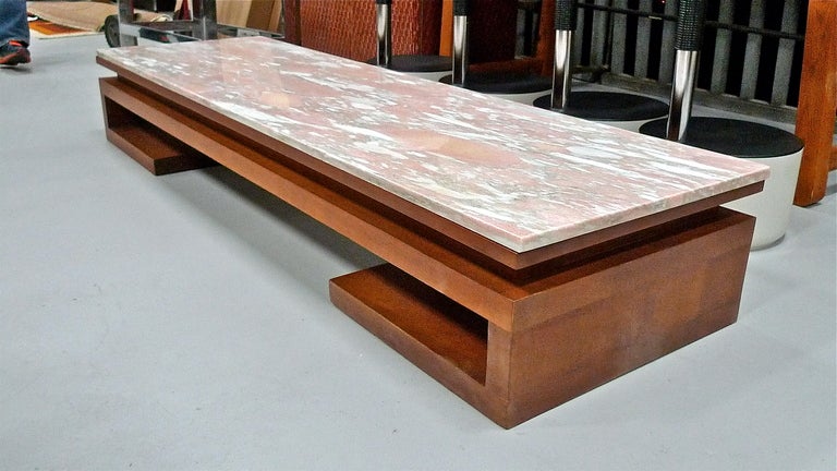 Stunning and rare long low display table in Greek key form by Paul Frankl circa 1948. The mahogany base is solid and actually heavier than the gorgeous original custom pink (Norwegian Rose) marble top. Outstanding example in excellent condition.