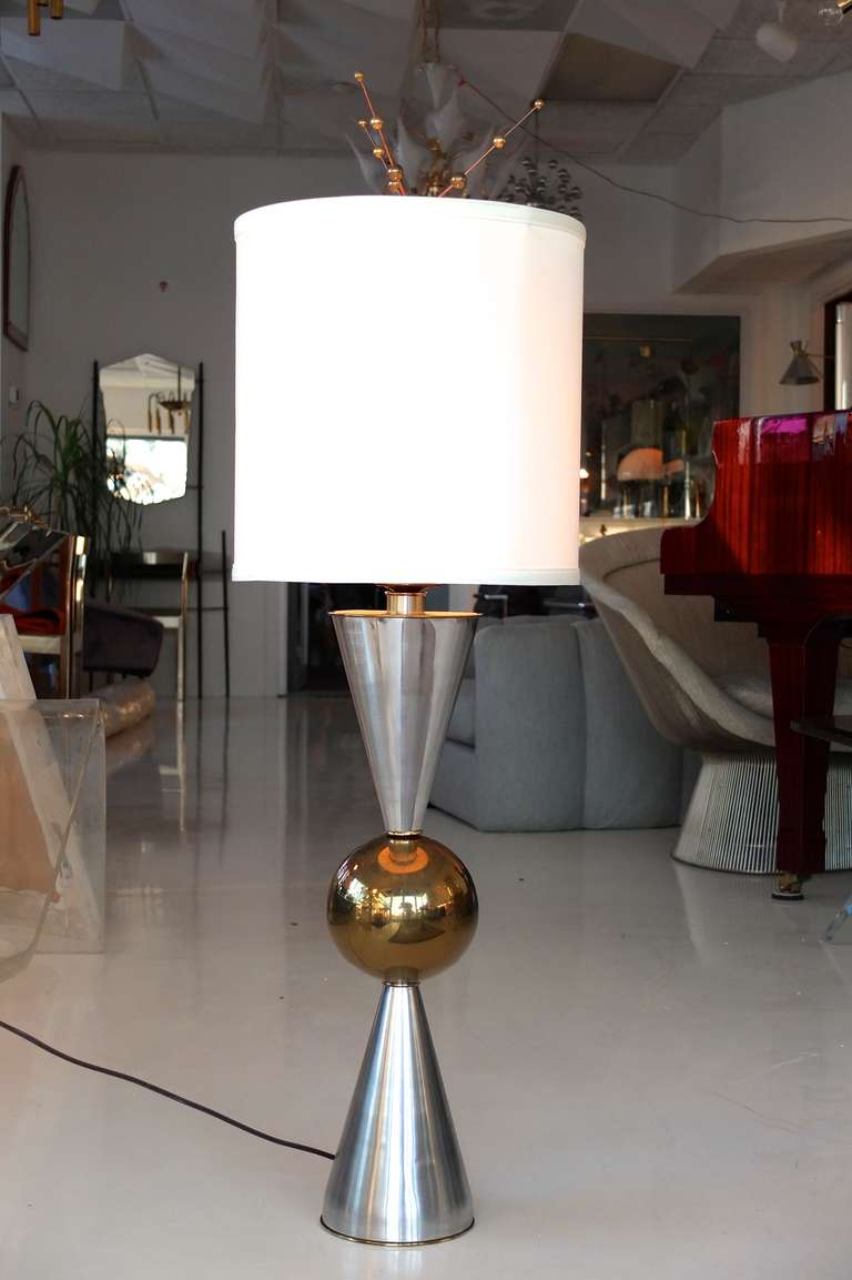 Lampe de table moderne du milieu du siècle à grande échelle, composée de deux cônes en aluminium filé et d'un grand orbe central en laiton.

La base a un diamètre de 6