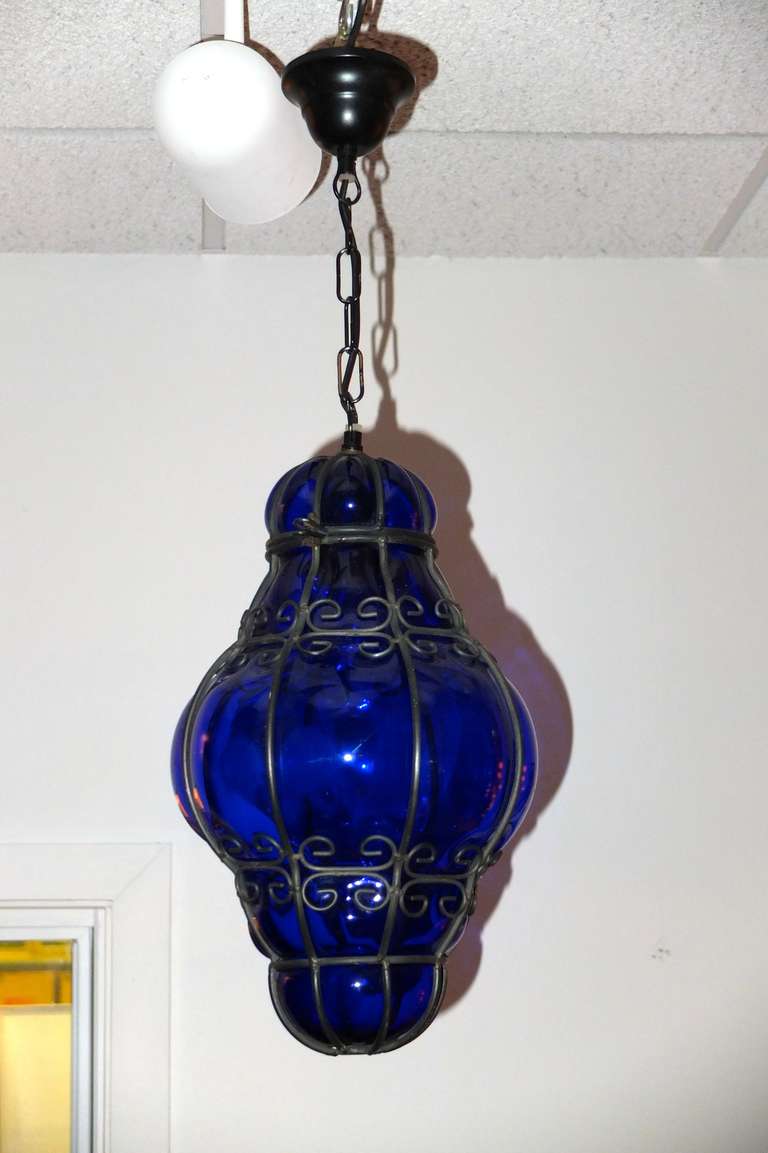 A Venetian wire cage lantern of blown bubble glass in the rare color of cobalt blue.  Can be used indoor or outdoor.  Single standard Edison screw cap bulb.

Glass is 15