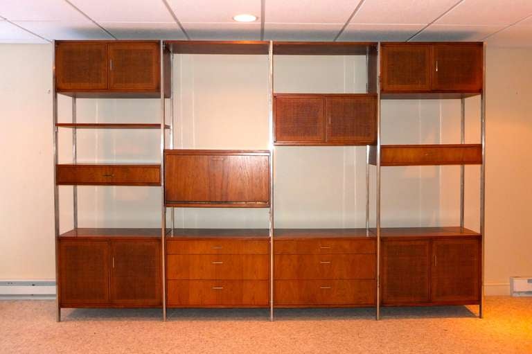 Modular wall unit or room divider from Founders Furniture Company. Solid walnut (not veneer) cases and shelves and polished aluminum scaffold. Cabinet doors in woven grass cloth. 

Total of ten cases and three shelves which can be configured in a