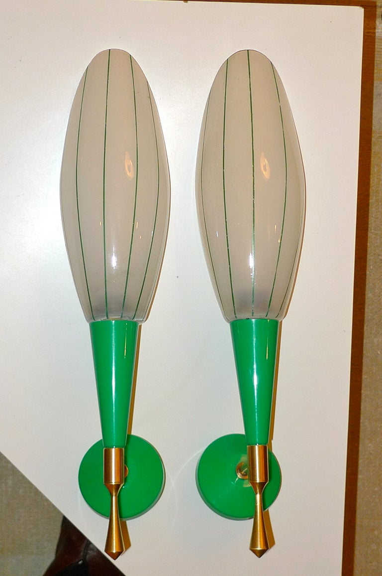 Pair of colorful French sconces from the 1960's in vibrant green with brass fittings and ovoid opaline glass shades which are pin-striped in green enamel.  Each takes one 40 watt candelabra bulb.  They are 14.5