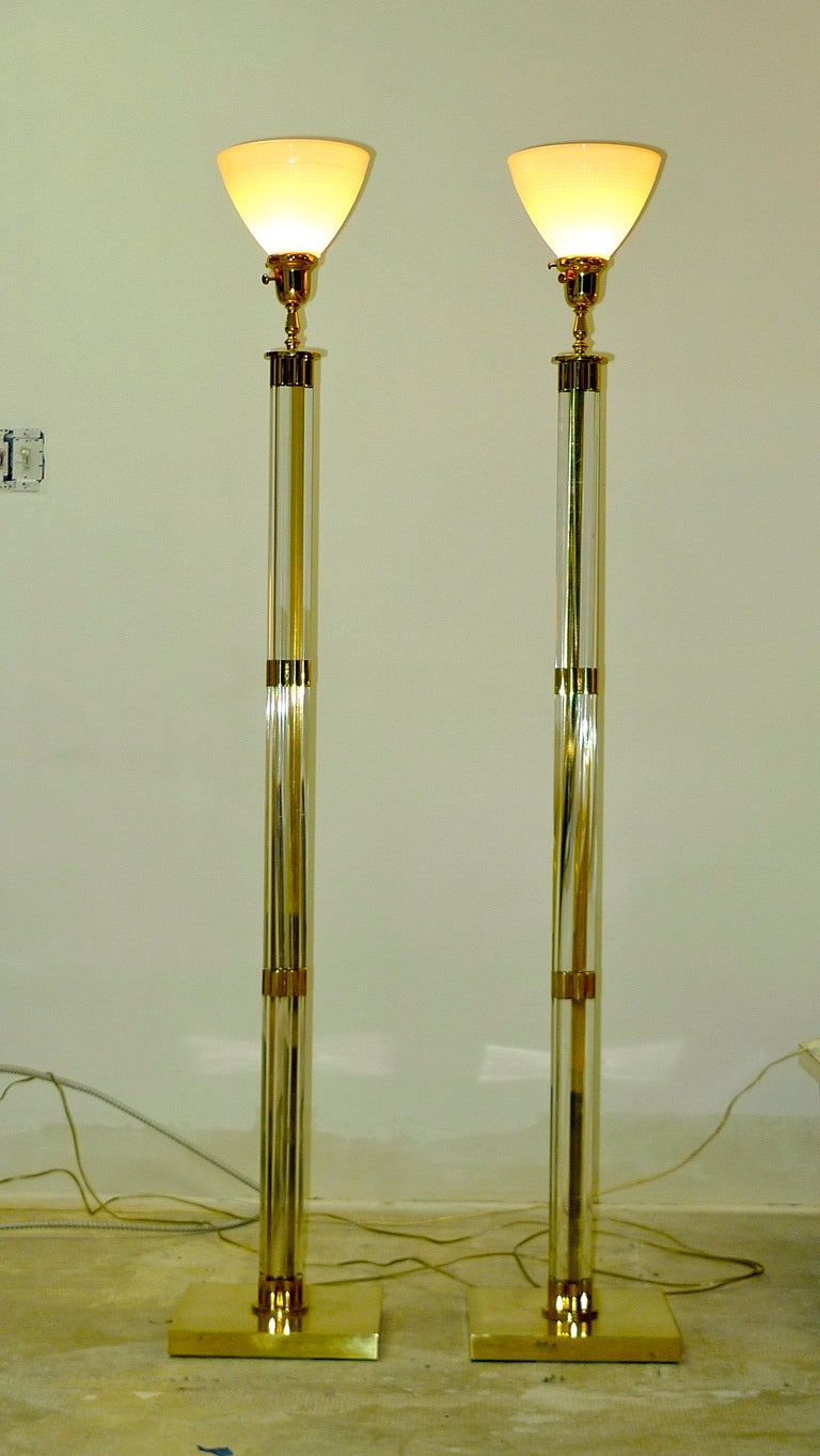 Classic pair of Lucite and brass floor lamps fitted with uplight white glass reflectors onto which can rest a lampshade.  In exceptionally clean condition.