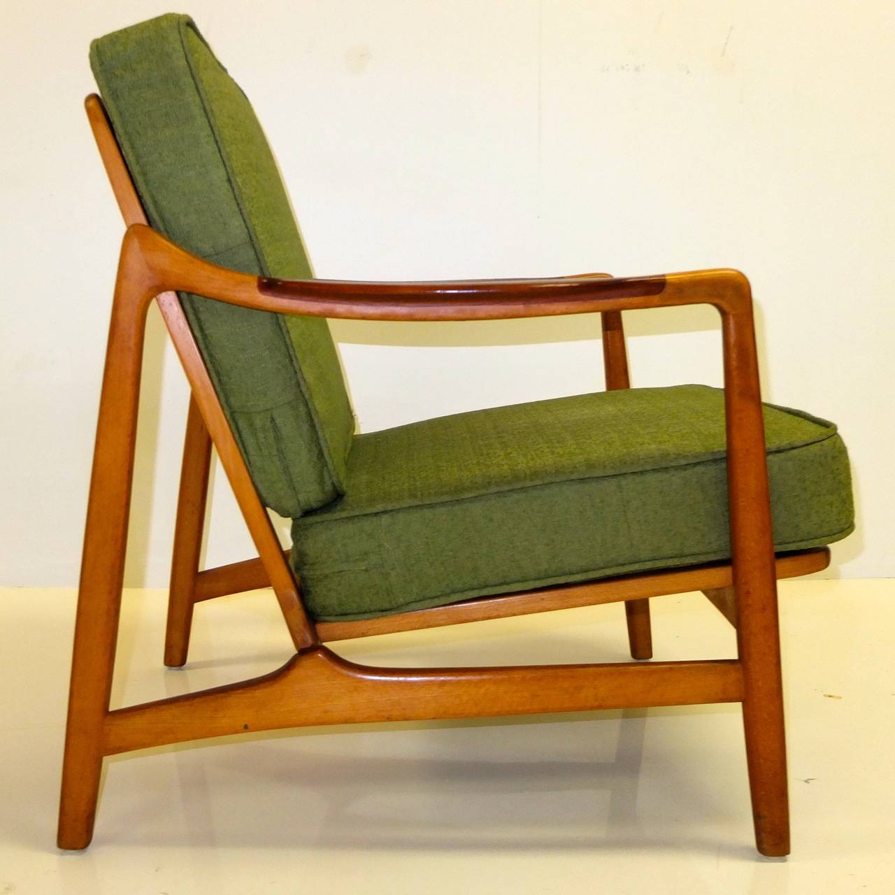 Uncommon design classic by Tove & Edvard Kindt-Larsen produced in Denmark by France & Daverkosen circa 1955 and retailed through John Stuart, New York. Shaped mahogany armrests on contrasting beech frame with keyhole joints allowing this chair to