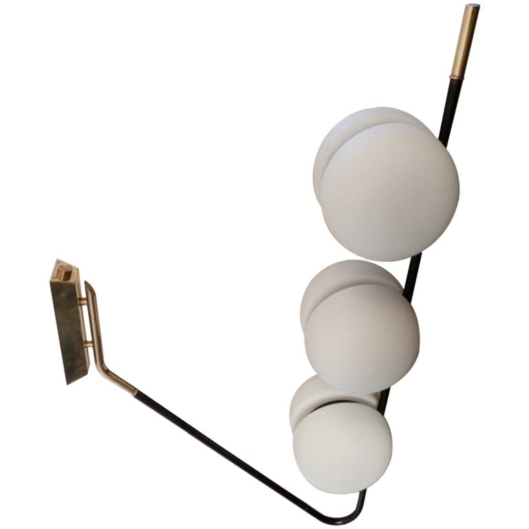 This large scale unusual French modernist fixture can be mounted either to a wall or ceiling and can be positioned pointed in either direction.  The elbow form enameled steel arm with brass fittings extends from a substantial rectangular brass