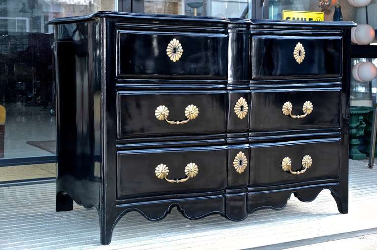 Italian serpentine chest of drawers with elaborate gilt brass hardware and escutcheons, hand polished black lacquer finish.