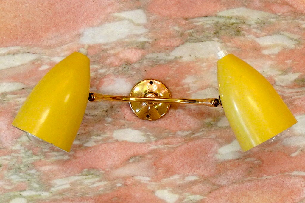 Charming brass and enameled aluminum wall or cabinet mounted sconces with double cone lights in yellow enameled aluminum.<br />
<br />
Takes two 40-60 watt candle bulbs.  Rewired.