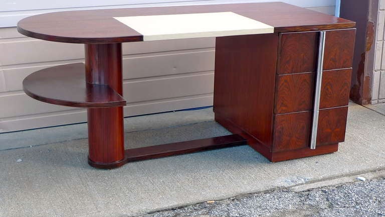 Important desk in rosewood by the illustrious French design firm Dominique-André Domin (1883-1962) and Marcel Genevriere (1885-1976) with leather top. Rounded on left side with a single floating demilune shelf supported by a single column connected