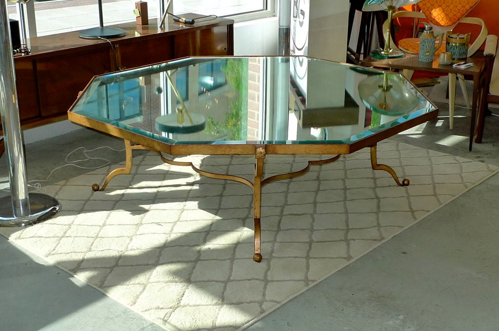 
Vintage French gilt wrought iron frame cocktail table in the manner of Rene Drouet. Double top with octagonal mirror below and clear cut beveled octagonal glass top.