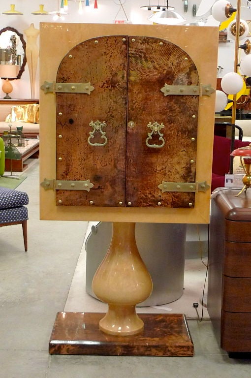 SATURDAY SALE


Late 1950's/early 1960's Italian standing bar cabinet with double doors by the 'Maestro of Parchment', Aldo Tura (1909-1963) in lacquered goatskin with illuminated mirror interior and fixed glass shelves.  Antiqued brass MODieval