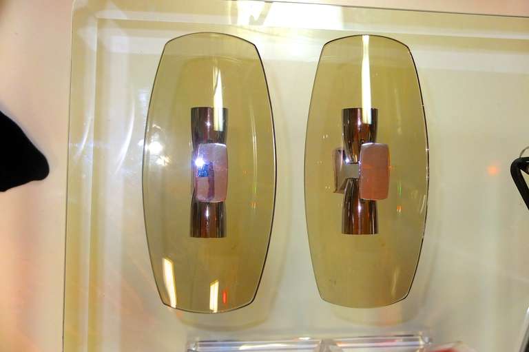 Pair of almost space age looking smoked curved glass sconces with chrome fittings, by Veca, in the style of Fontana Arte. Chrome armature.

We have two pair available.