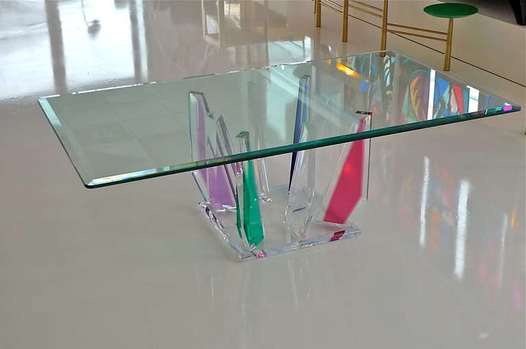 Arresting vintage lucite coffee table with rectangular glass top supported by asymmetric rainbow colored acrylic slabs in organic mineral forms.

In the manner of Shlomi Haziza.