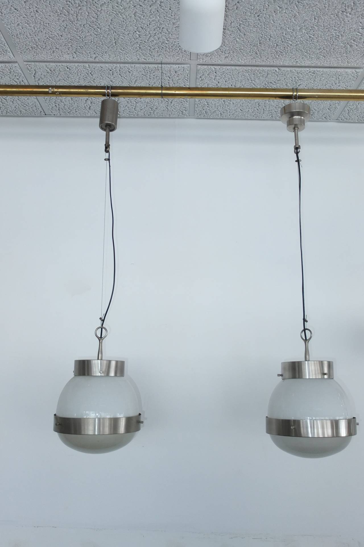 SATURDAY SALE $1750 per pendant.

We currently have a pair of medium sized pendant lights from the Delta series by Sergio Mazza for Artemide, Italy, 1960. The metal is brass that has been satin nickel plated, the globe is milk glass and the lens is