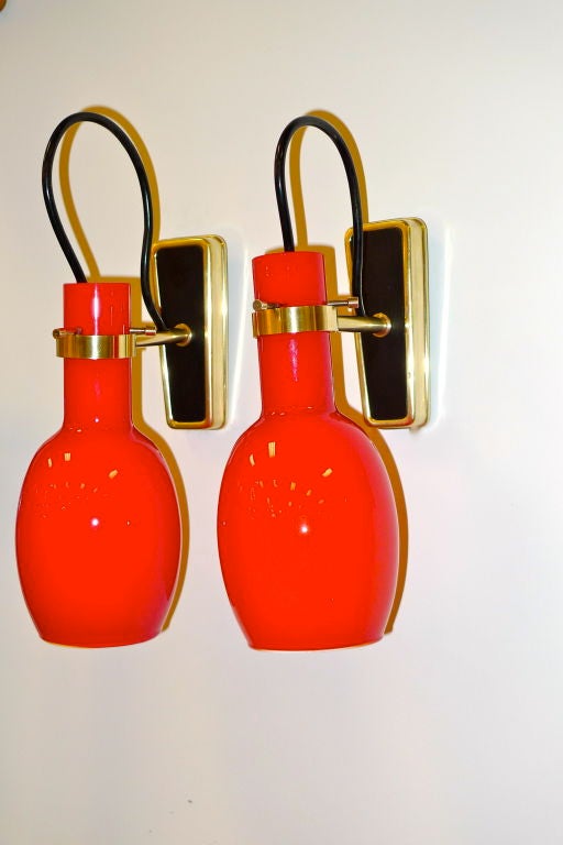 Utterly gorgeous pair of 1950's Italian sconces by Vistosi with inverted red cased glass reflectors suspended from a solid brass ring and three brass  pins.