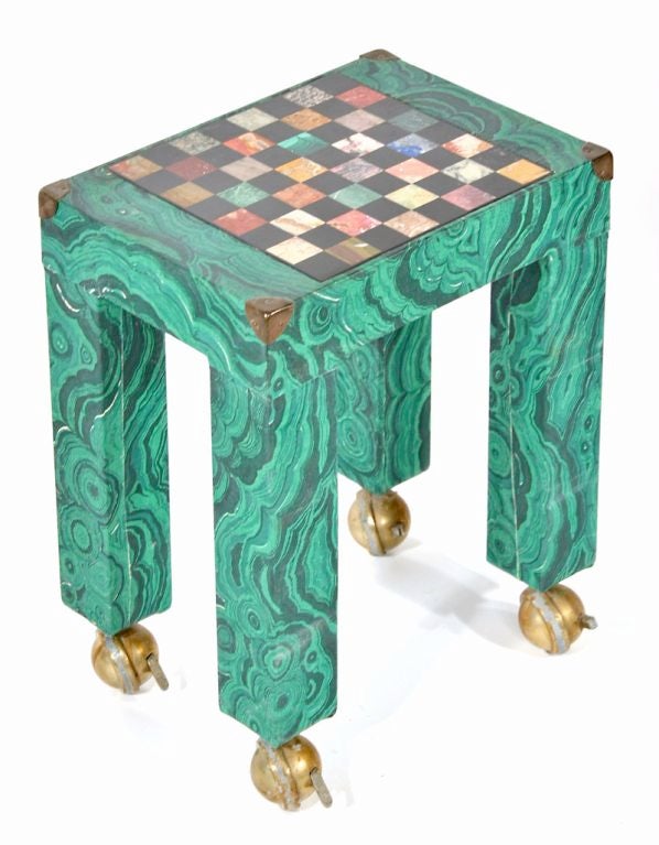 A single green Malachite paper decorated occasional table with brass corners and raised on ball casters with an inset pietra dura game board. 
In the style of Piero Fornasetti.
18hx14wx10d


The second table shown in the photos is no longer